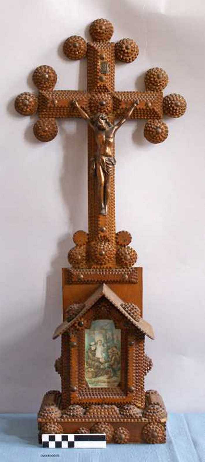 Kruisbeeld op sokkel in houtsnijwerk